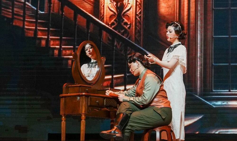 Two leads at a dressing table in a scene from The Message