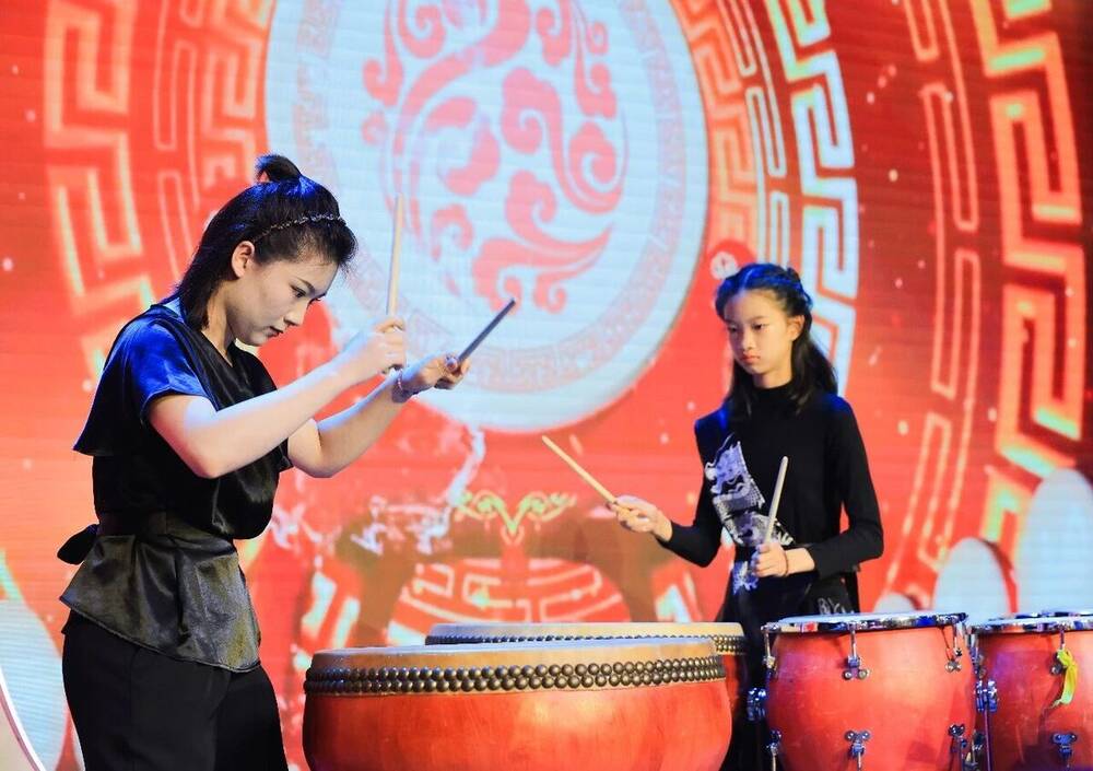 Two students at a pair of large Chinese drums during the folk music number