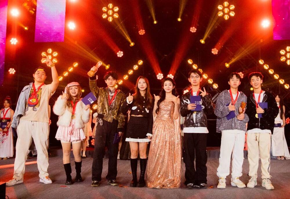 The full company of the Voice of HFLA final lined up on stage under red lights