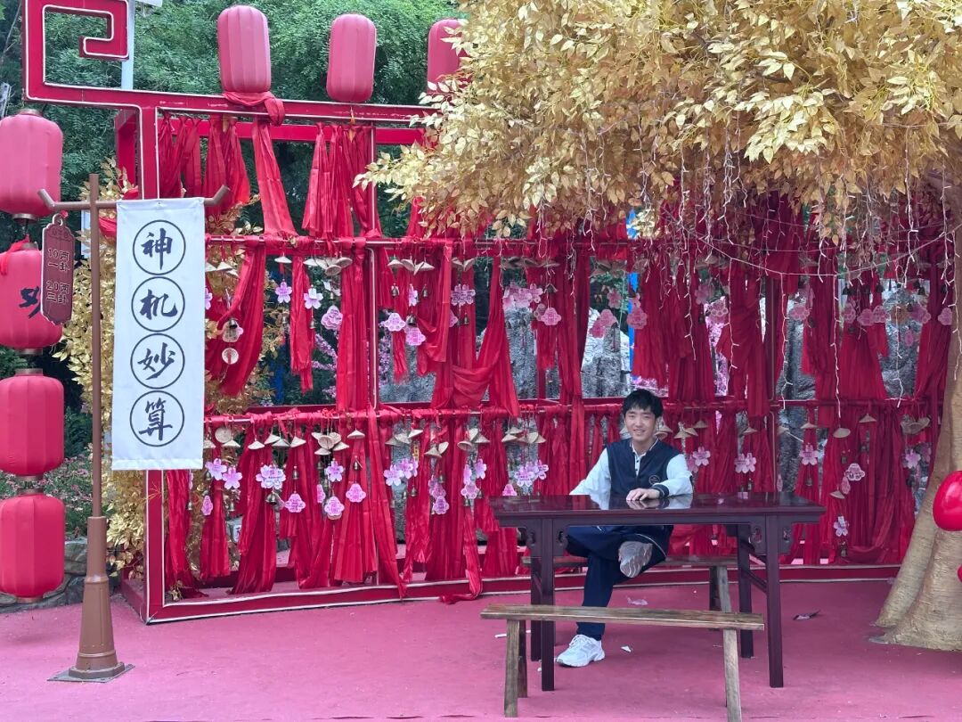 A young Shen Hongqiu standing beside an inflatable orange car at a fairground