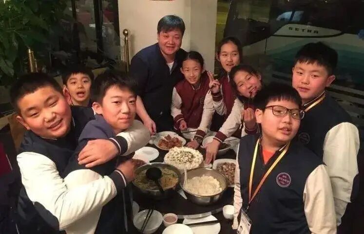 A group of students sharing a meal around a table after a school orchestra performance
