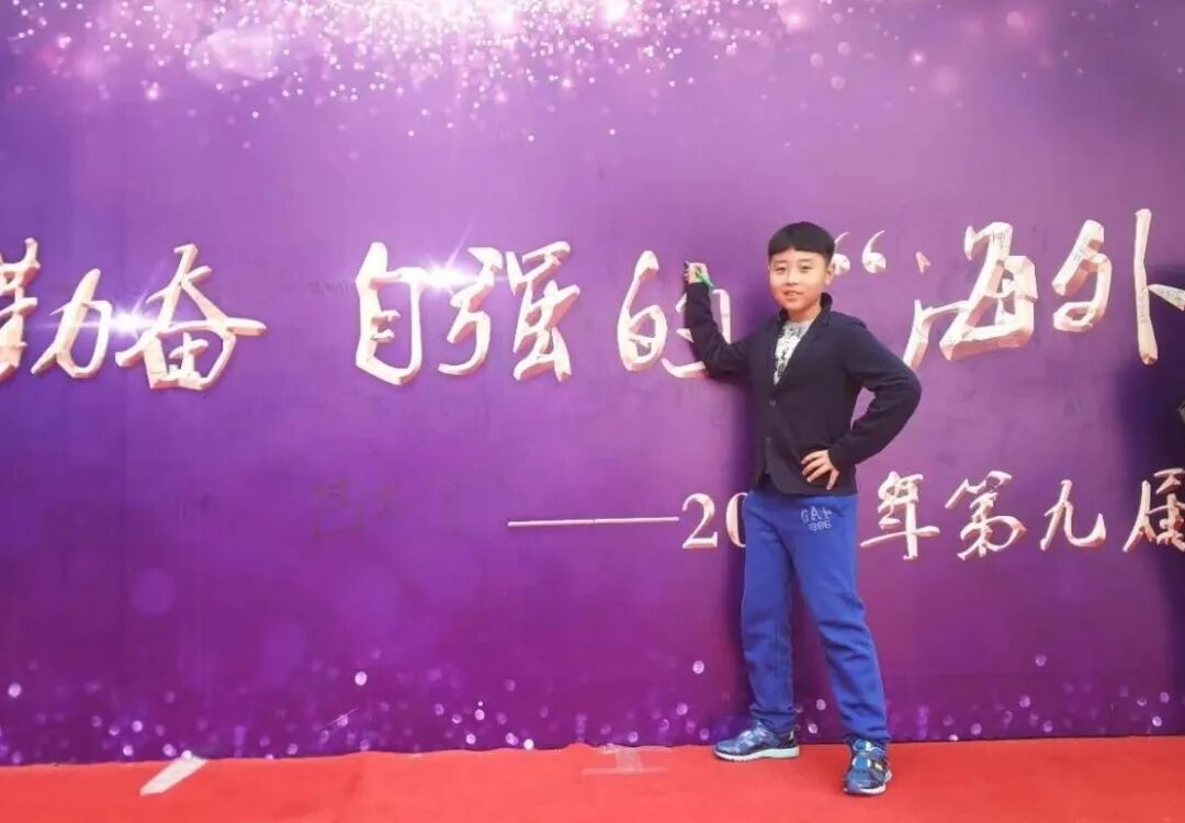 A student speaking on a stage lit in purple during a school event