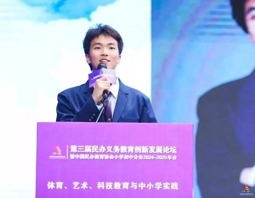 Ma Liangyu speaking into a microphone at a forum on behalf of the school