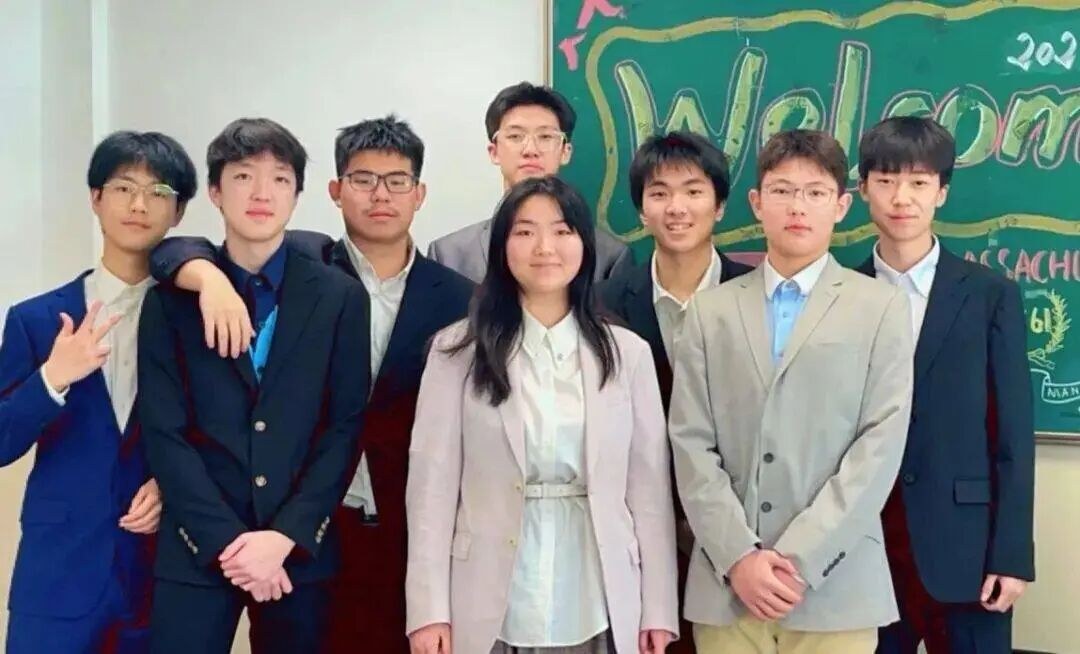 Ma Liangyu with his AP Seminar class in formal dress before a decorated blackboard, third from the right