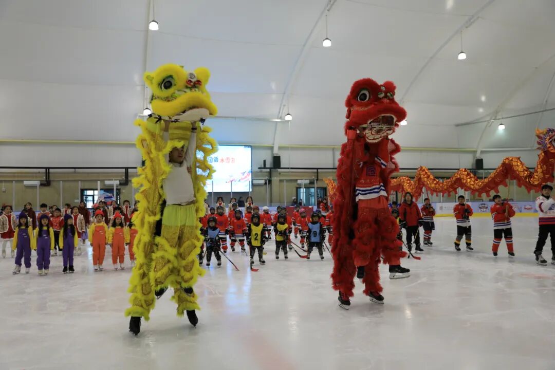 Lion dancers on the ice with young hockey players behind them