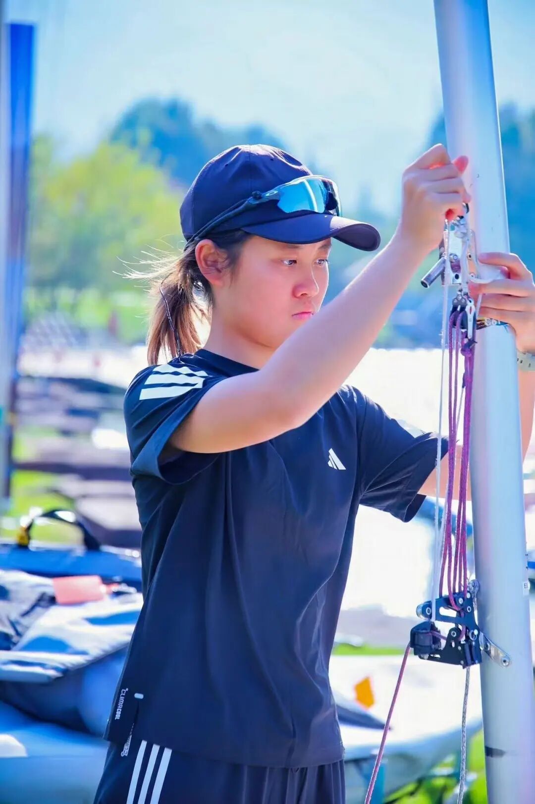 A sailor rigging an ILCA dinghy before racing